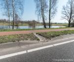 Water loopt over het fietspad naar de groenstrook, rondweg